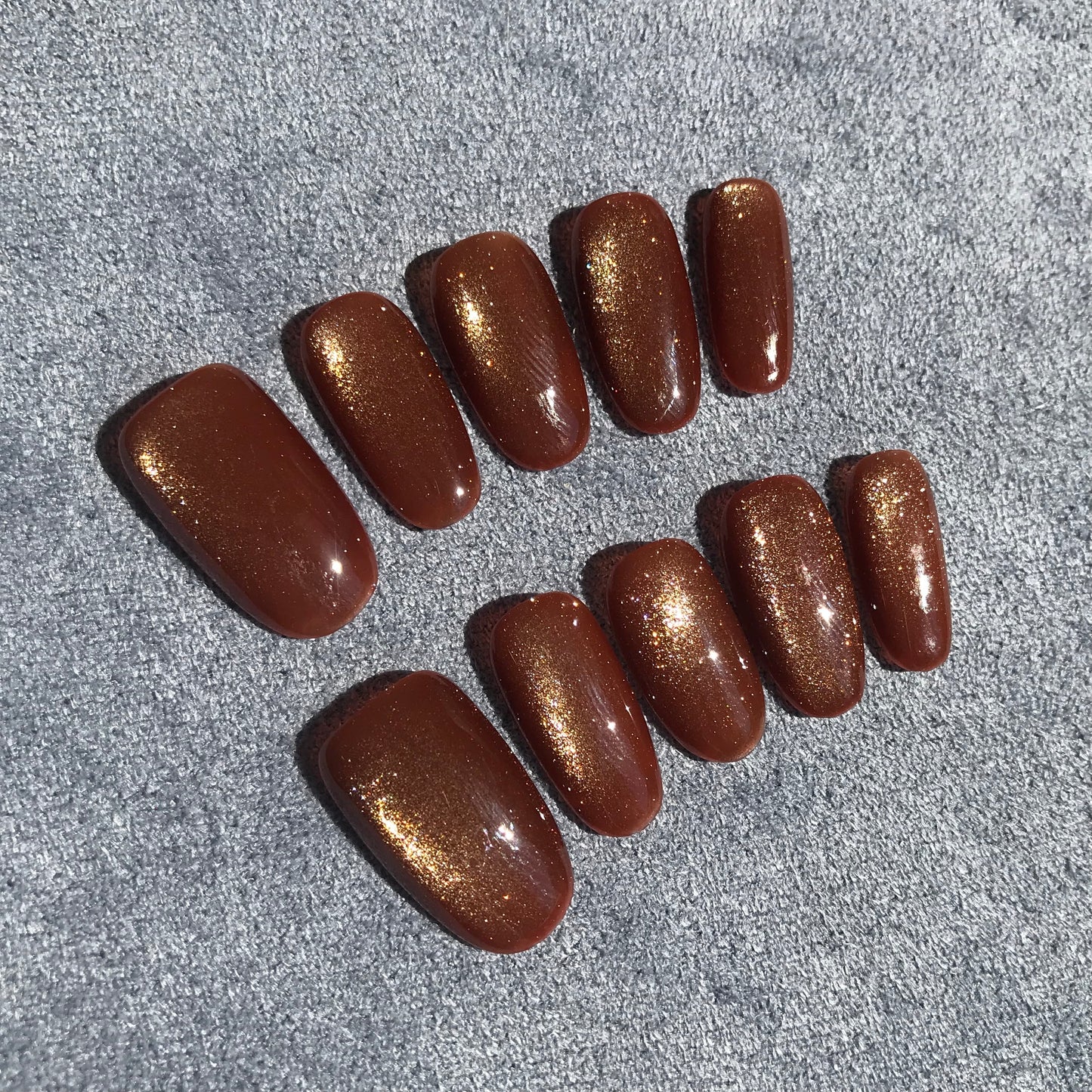 Calm Storm premium press-on nails with a shimmering gold magnetic finish.