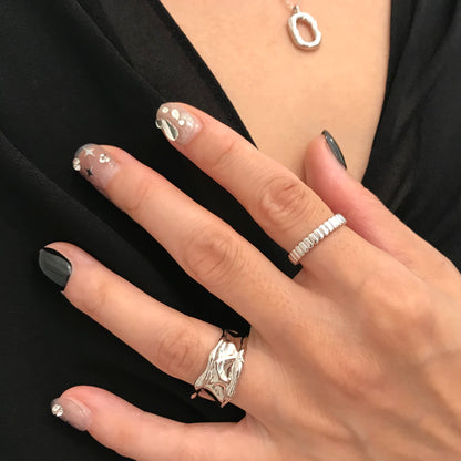 Lifestyle shot of black and sliver sparkle press-on nails in extra short modern design. 