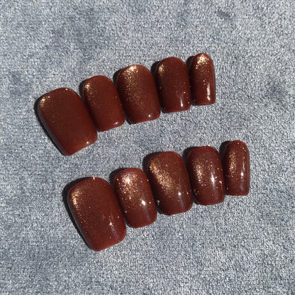 Calm Storm premium press-on nails with a glossy dark brown base and fine gold glitter.
