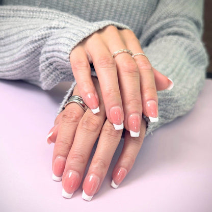 Close-up of hands with salon quality French style press-on nails in medium square
