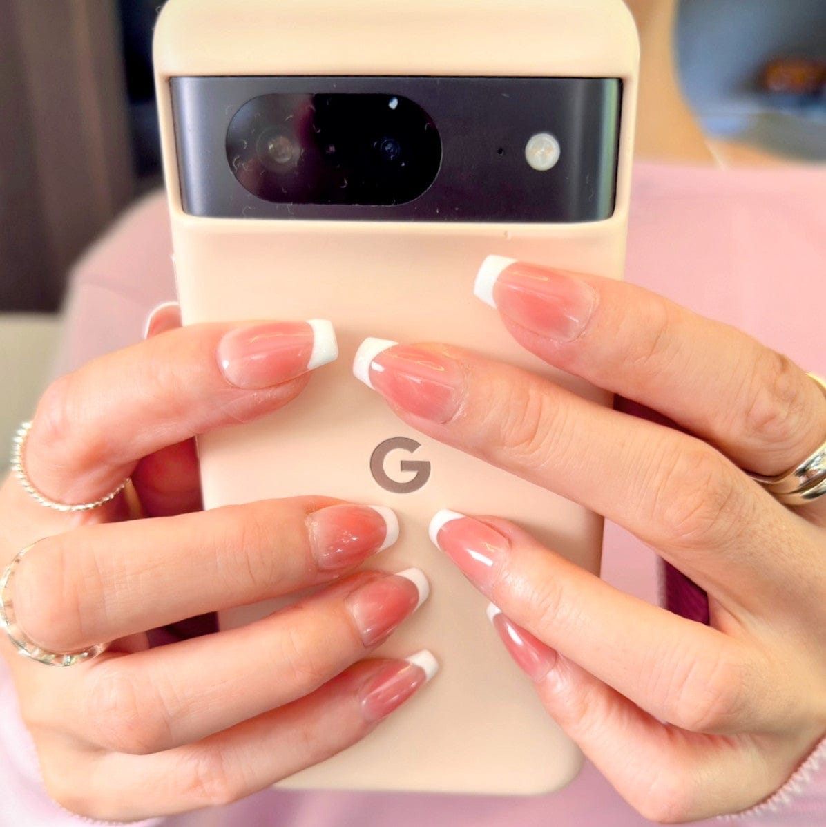 Close-up of hands modelling modern french white press-on nails in medium square