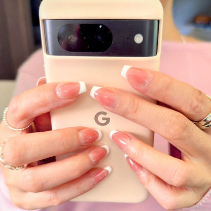 Close-up of hands modelling modern french white press-on nails in medium square