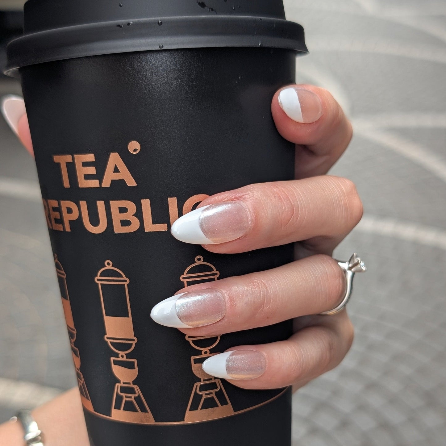 Lifestyle shot of French tip press-on nails with Chrome detail