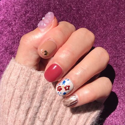 Close up of red gold glitter luxury press on nails with 3d floral design extra short