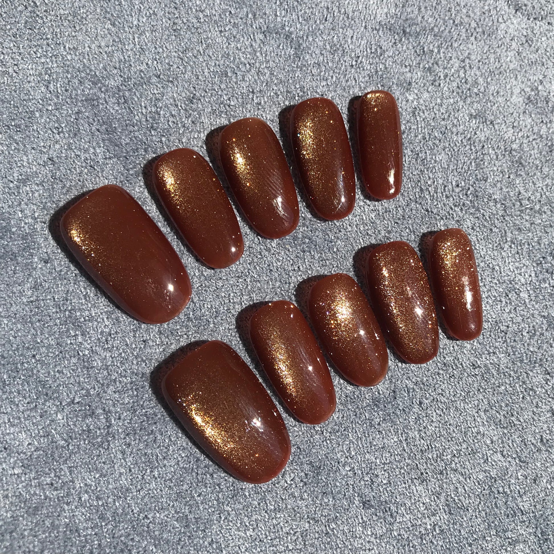 Calm Storm premium press-on nails with a shimmering gold magnetic finish.