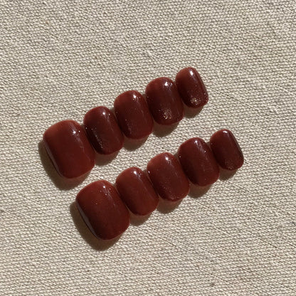 Calm Storm premium press-on nails in rich caramel cat eye effect in extra short round  shape.  