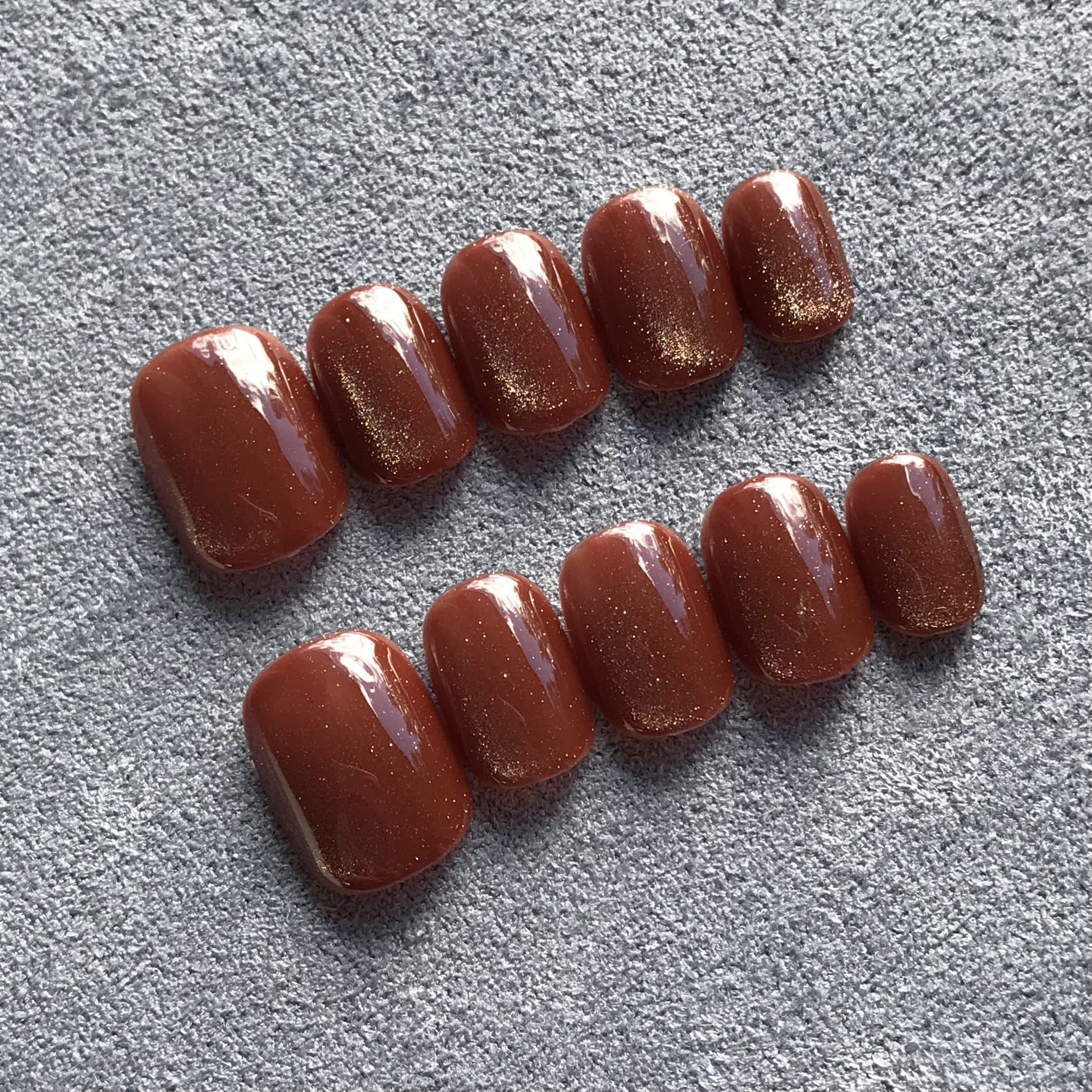 Calm Storm handmade press-on nails in rich caramel cat eye effect in extra short round  shape.  