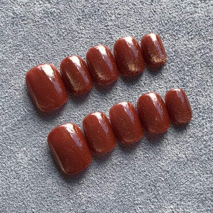 Calm Storm handmade press-on nails in rich caramel cat eye effect in extra short round  shape.  