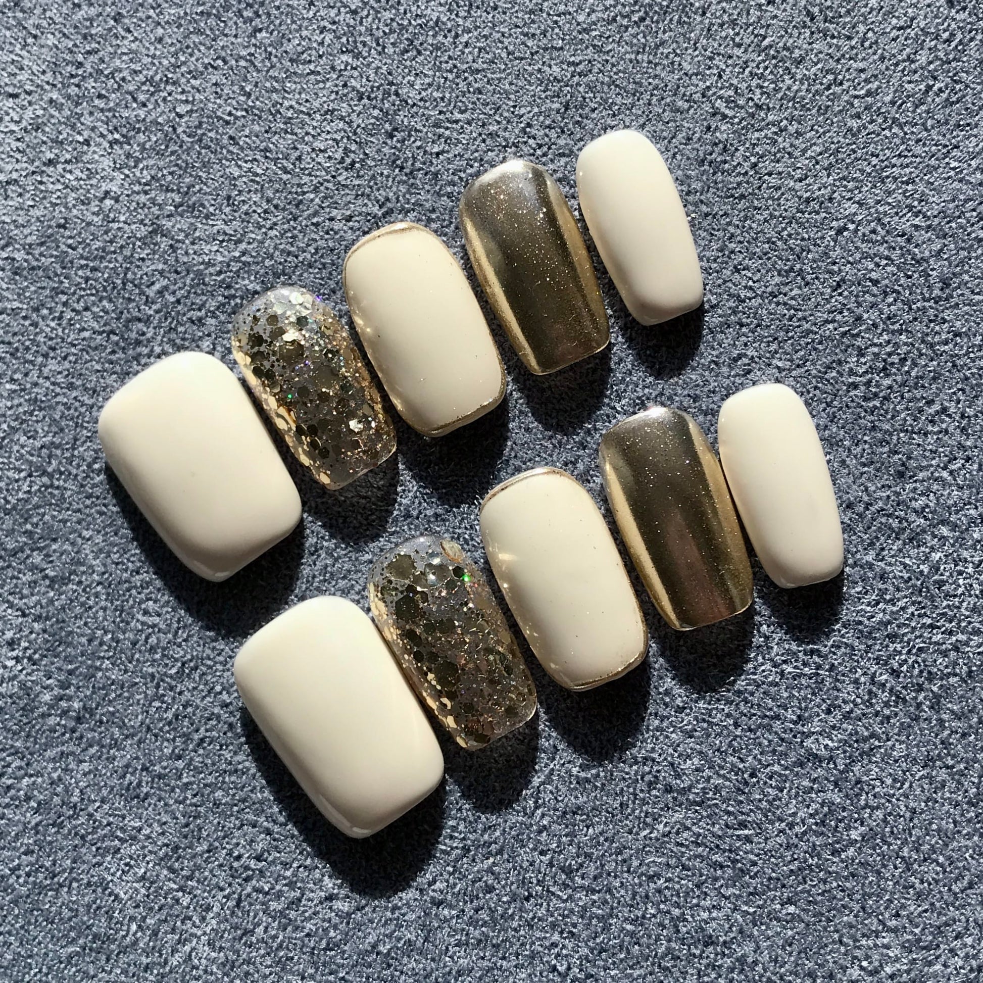 Premium salon quality press-on nails in contrasting white and gold with gold glitter. 
