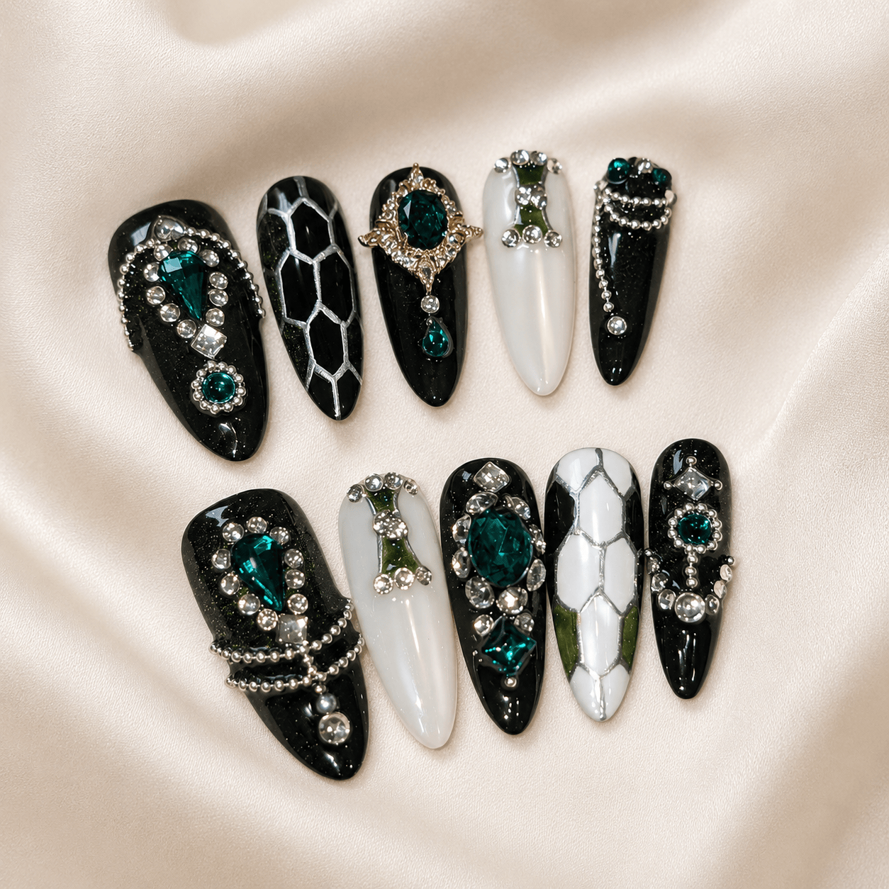 Calm Storm premium press on nails featuring glossy marble designs, embellished with green gemstones and silver bead details.