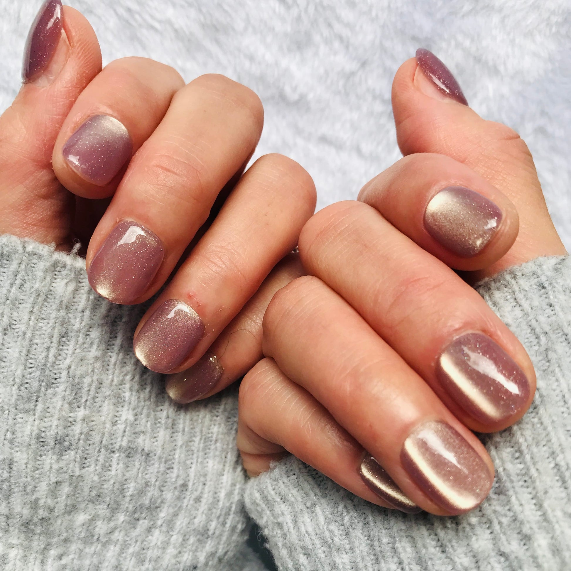 Close-up of hands wearing extra short lavender coloured press-on nails. 