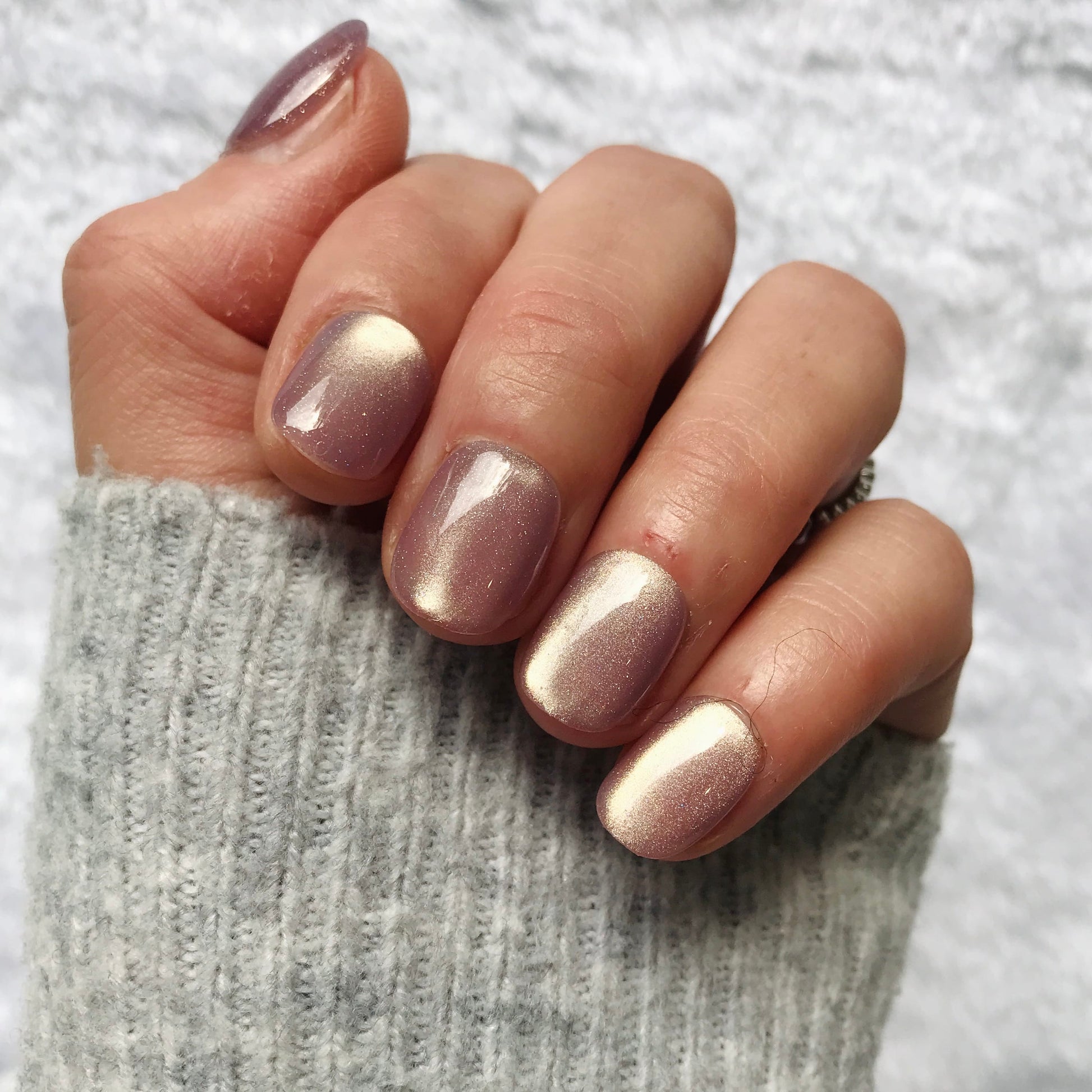 Hand with metallic lavender press-on nails in extra short. 