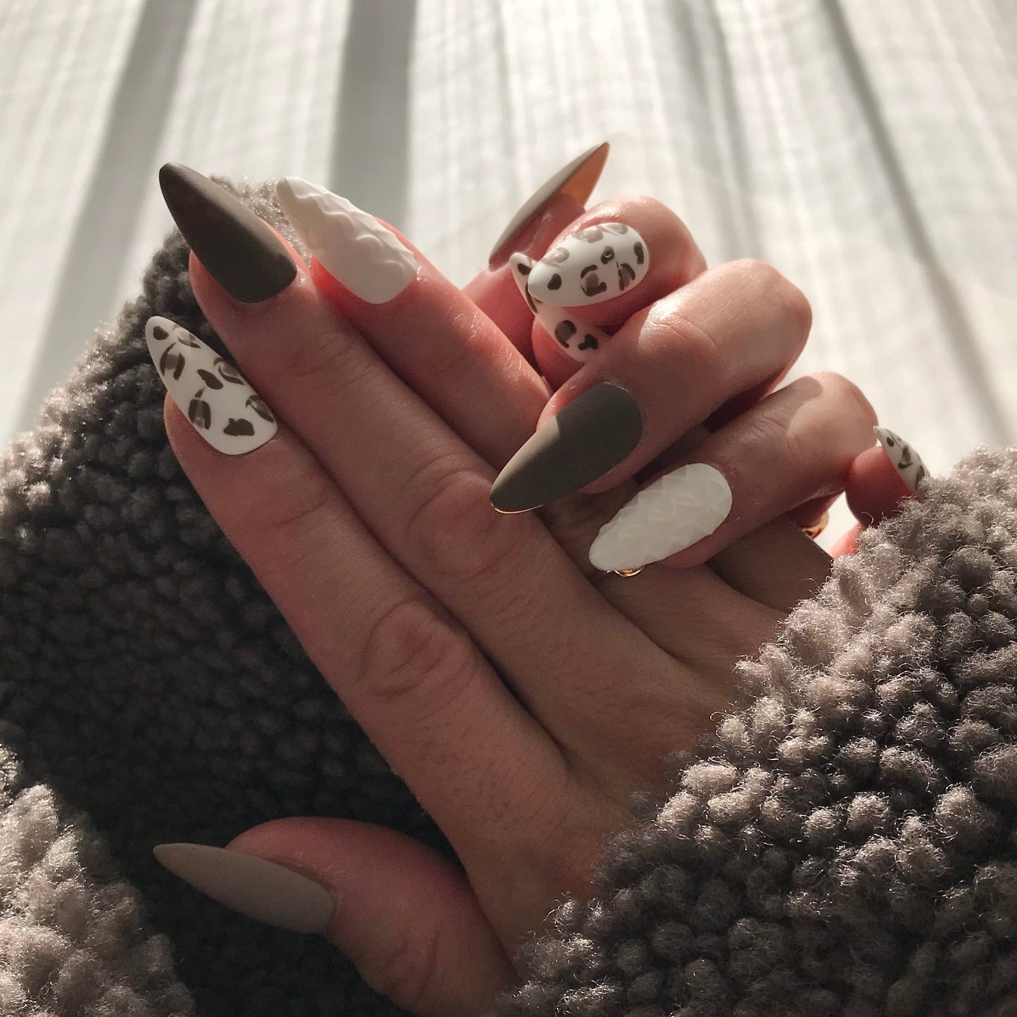 Close-up of a hand with stylish press-on nails art in medium almond shape
