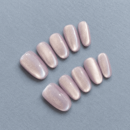 Oval shaped press-on nails with a glossy, shimmery pale lavender pink finish.