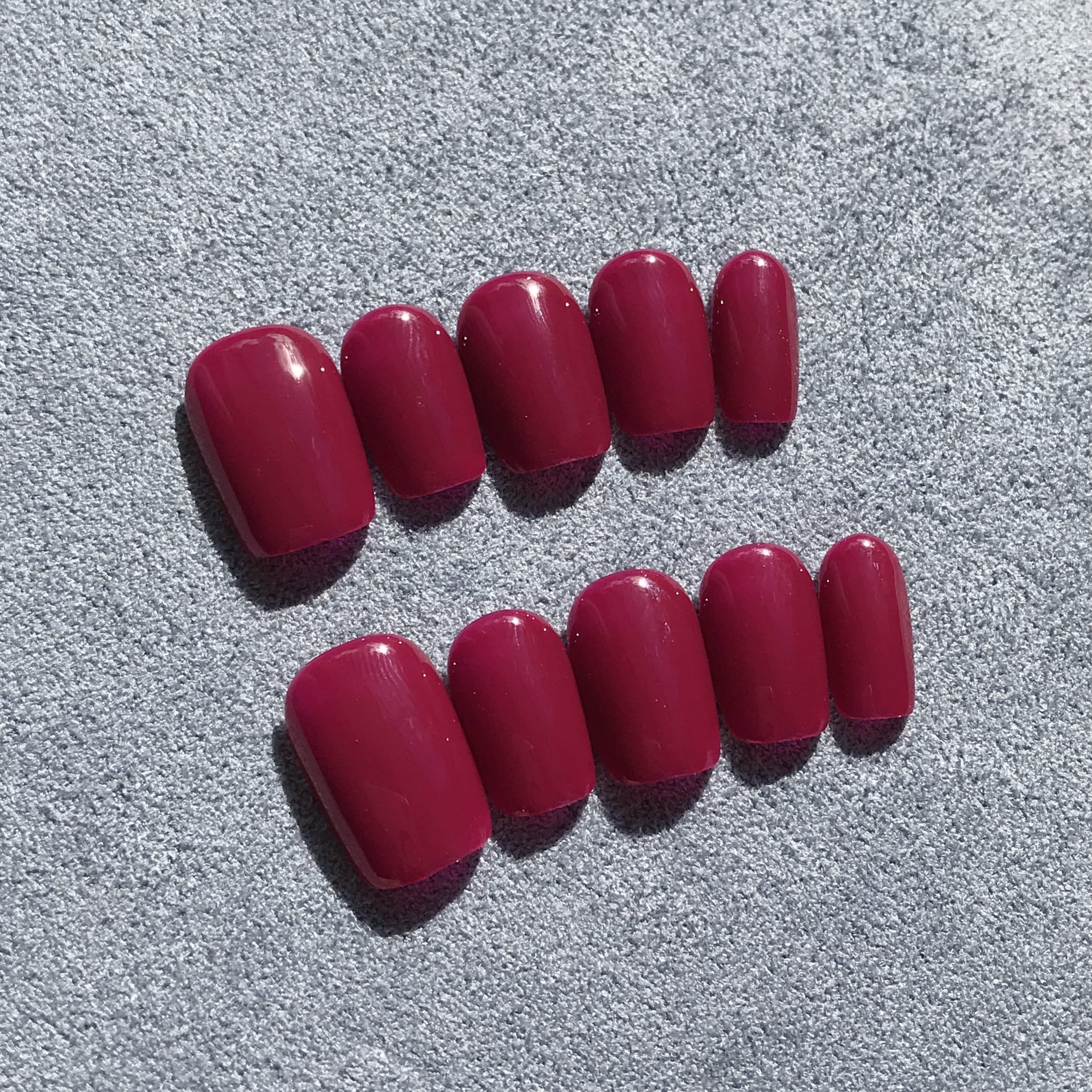 Handmade press-on nails in deep magenta in extra short square. 