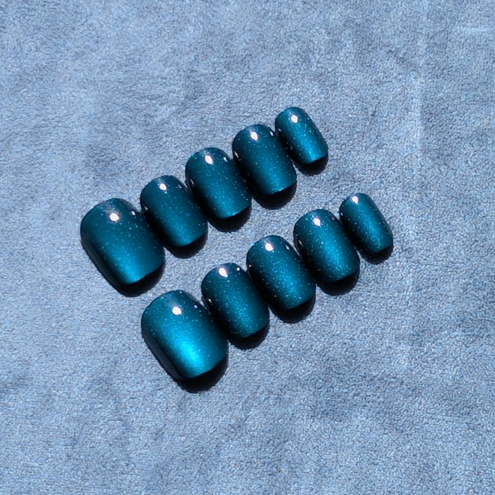 Close up of premium dark blue press-on nails in extra short