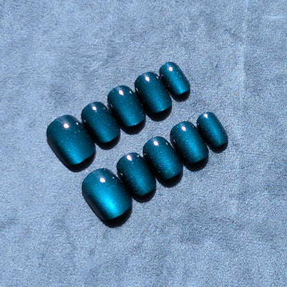 Close up of premium dark blue press-on nails in extra short