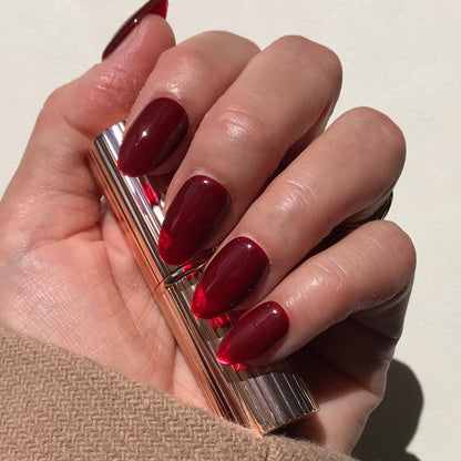 Luxury handmade  press-on nails in classic cherry red in medium almond.