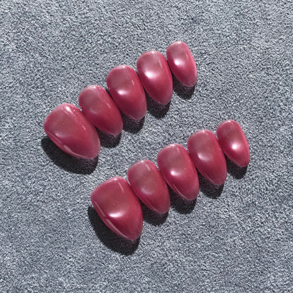 Premium handmade pink press-on nails in medium almond shape  with glittering cat eye design. 
