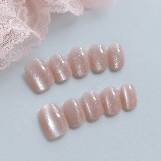 Calm Storm handmade press on nails in light pink with glittering cat eye design. 