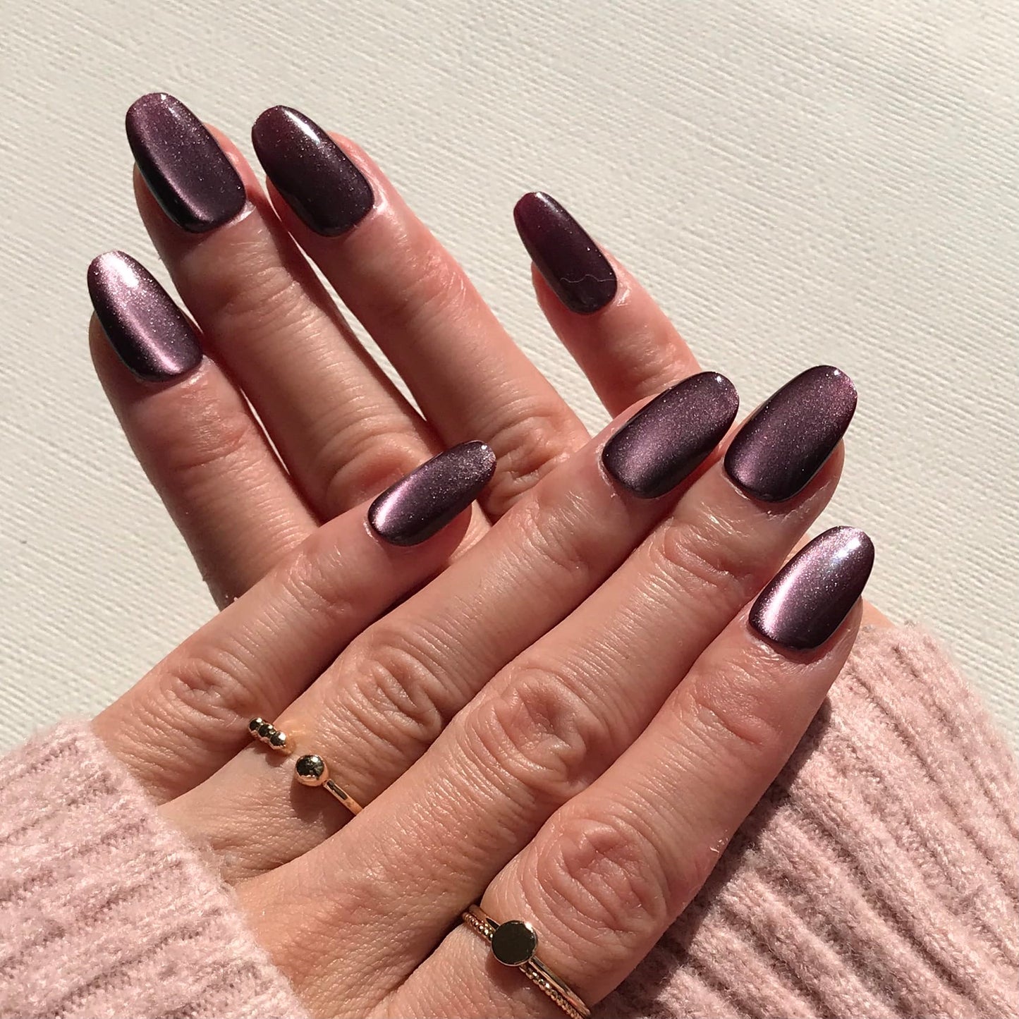 Close-up of handmade dark purple press-on nails.