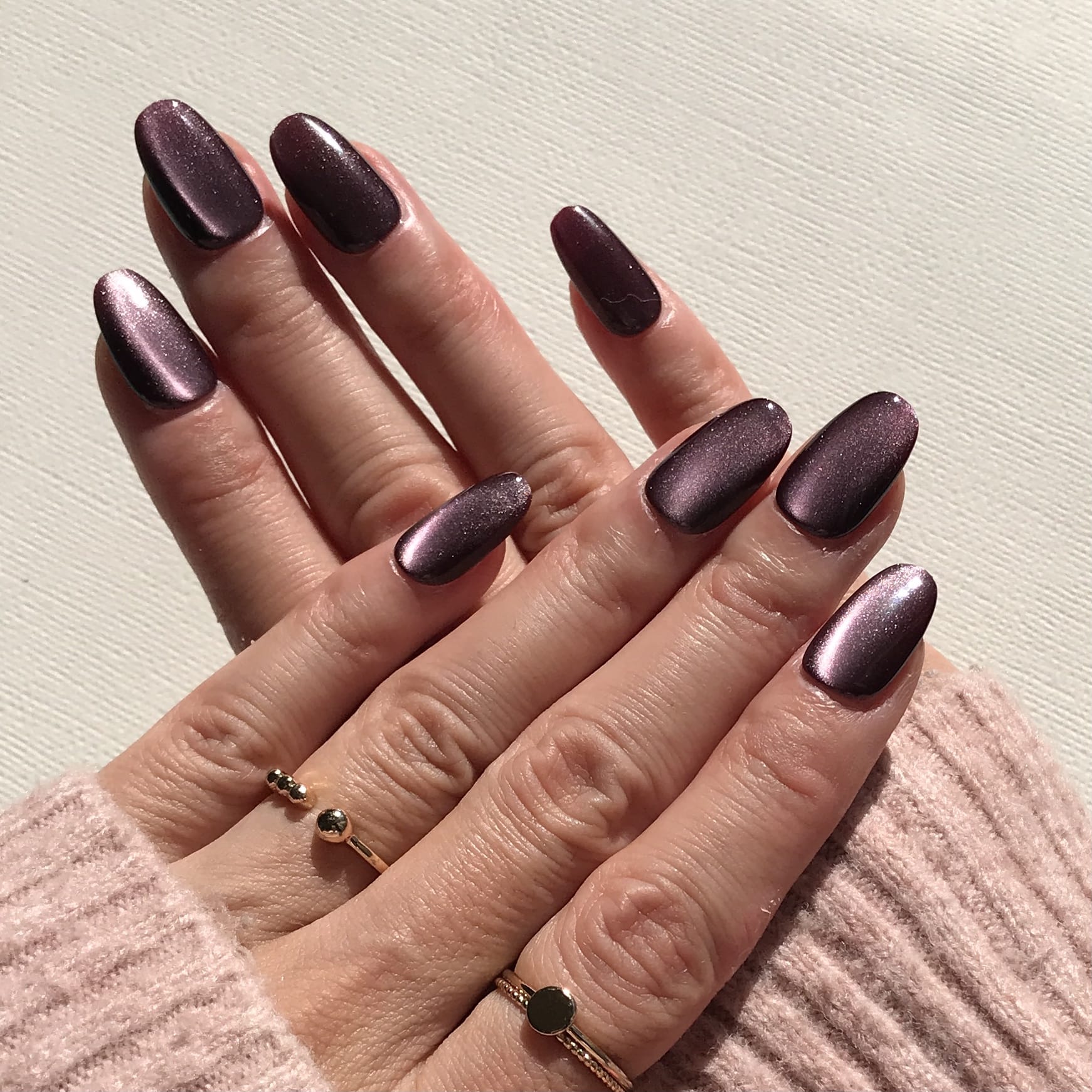 Close-up of handmade dark purple press-on nails.