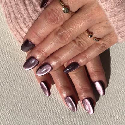Close-up of hands with metallic purple press-on nails with a salon finish. 