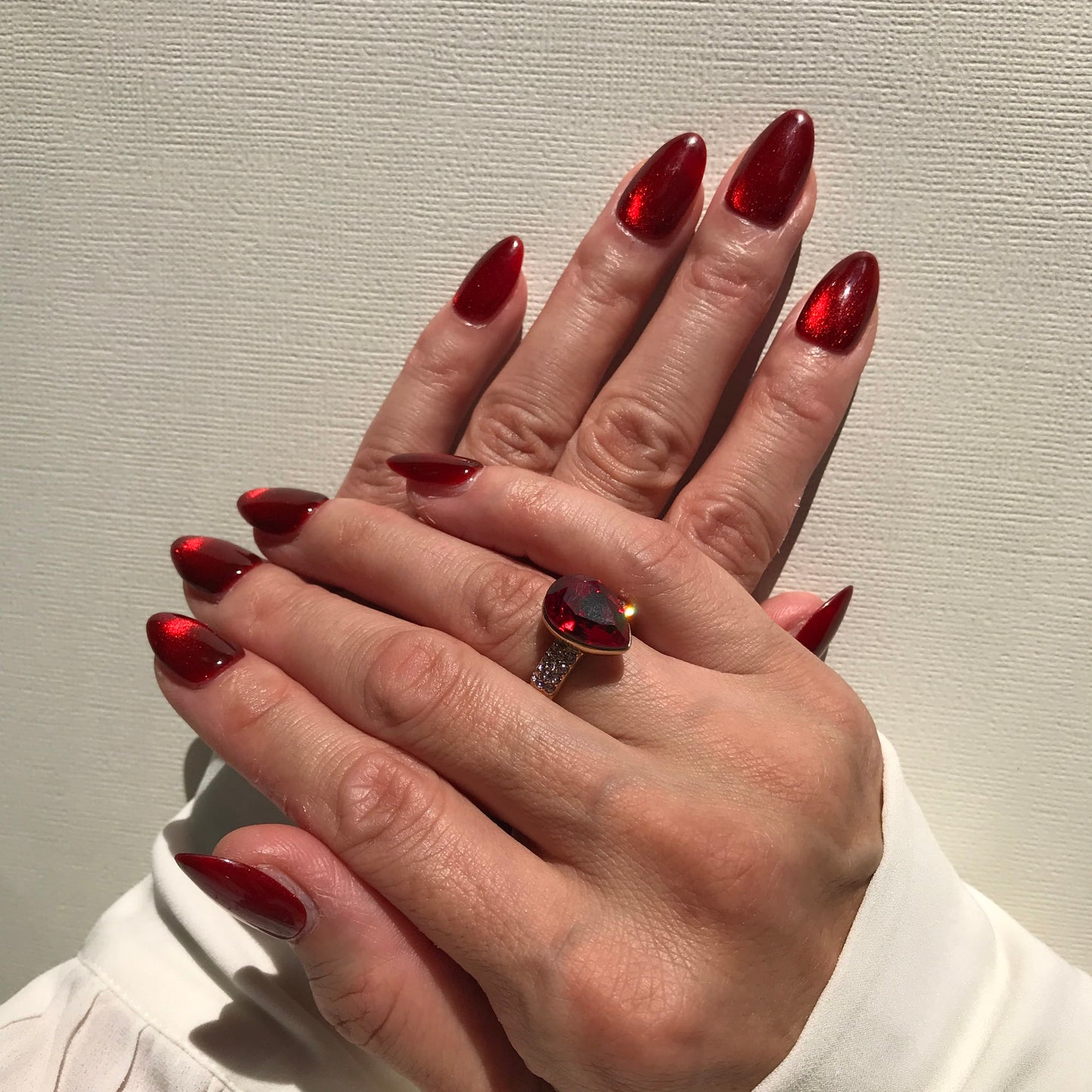 Hand modelling gorgeous red cat eye press-on nails.