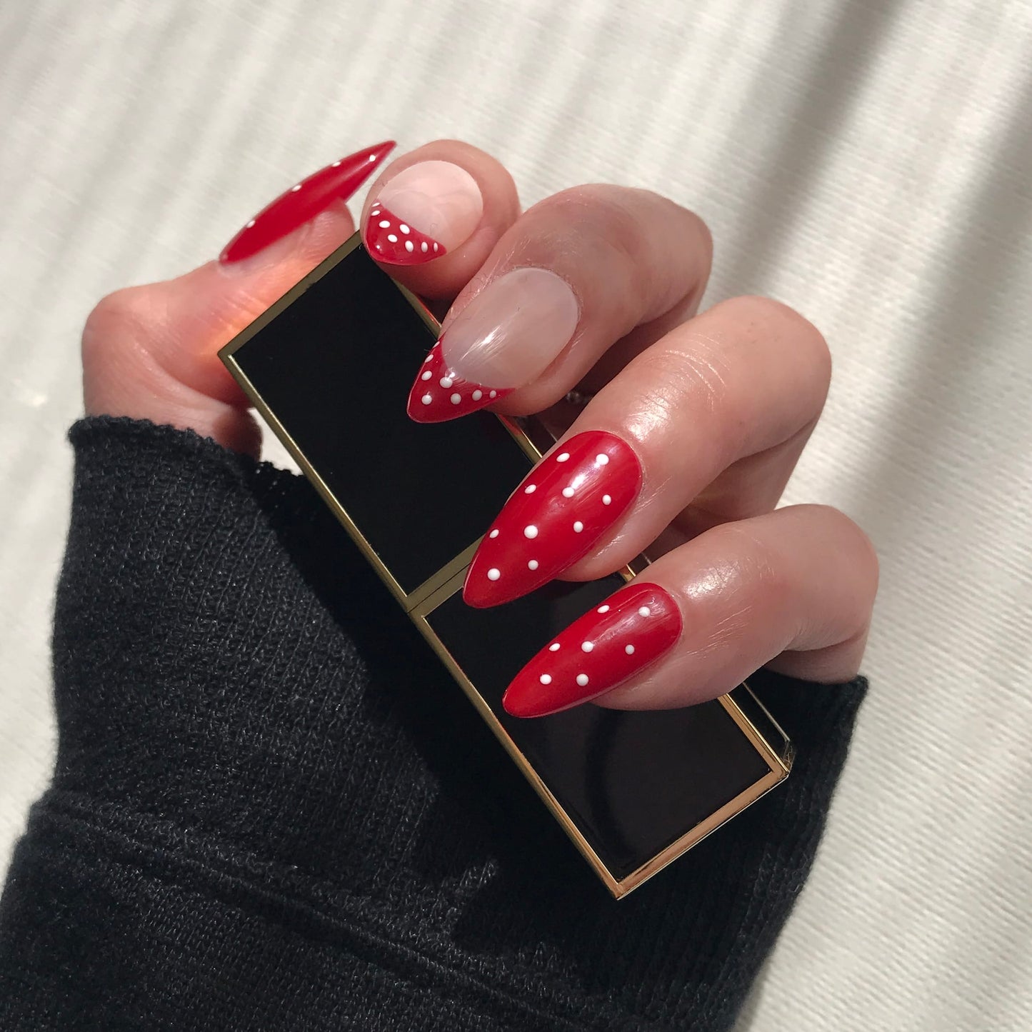 Handmade red press-on nails with white polka design. 