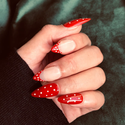 Premium press-on nails in red and white polka design in medium almond. 