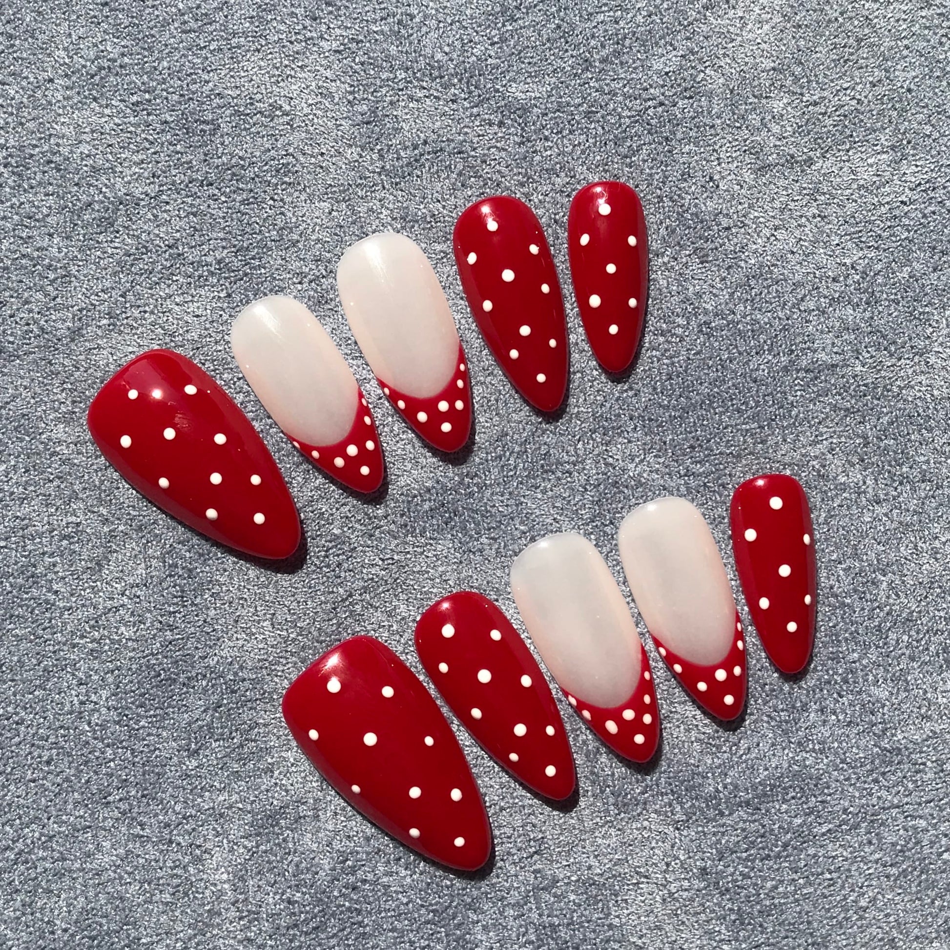 Red press-on nails with polka dots design.