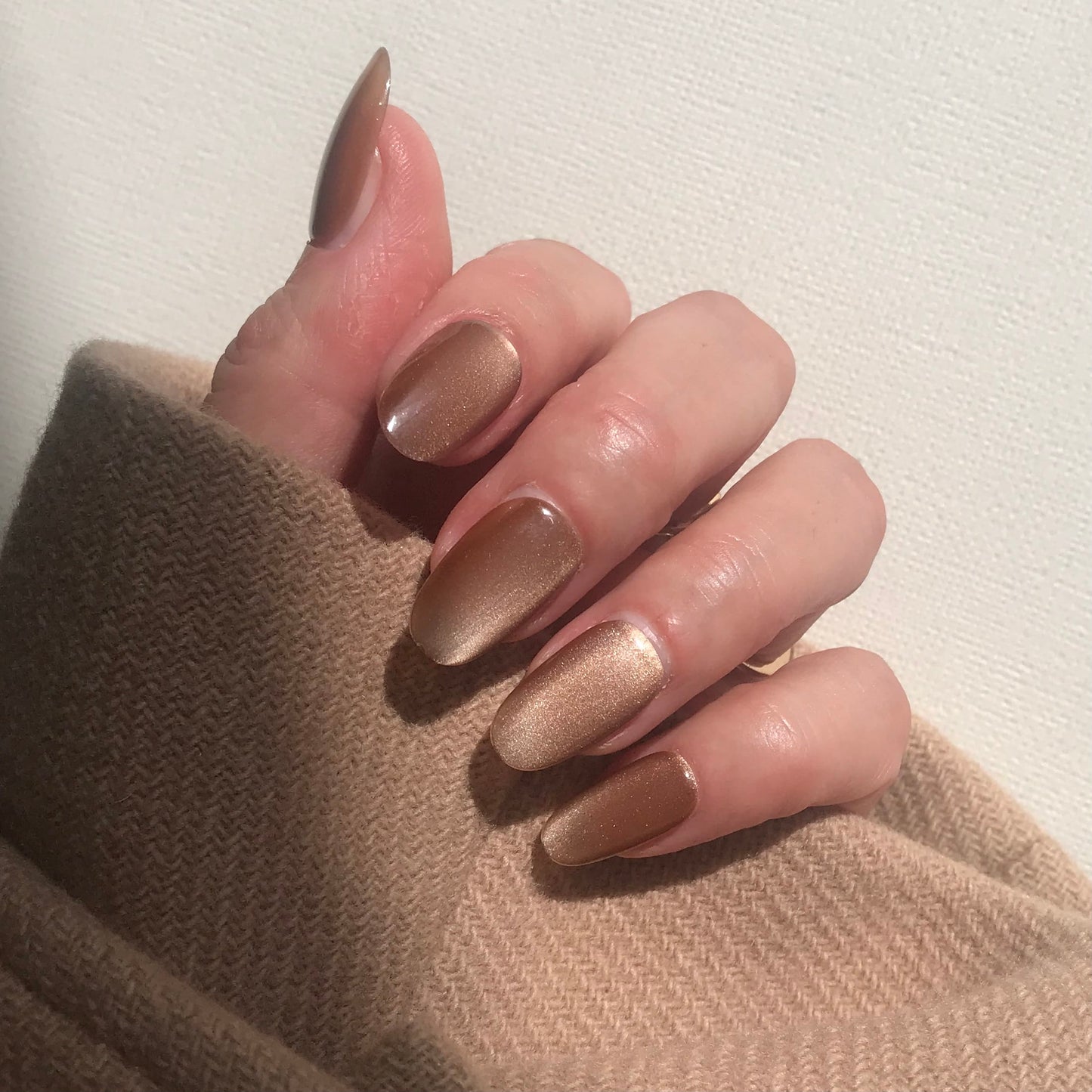 Handmade neutral toffee cat eye press on nails close up. 