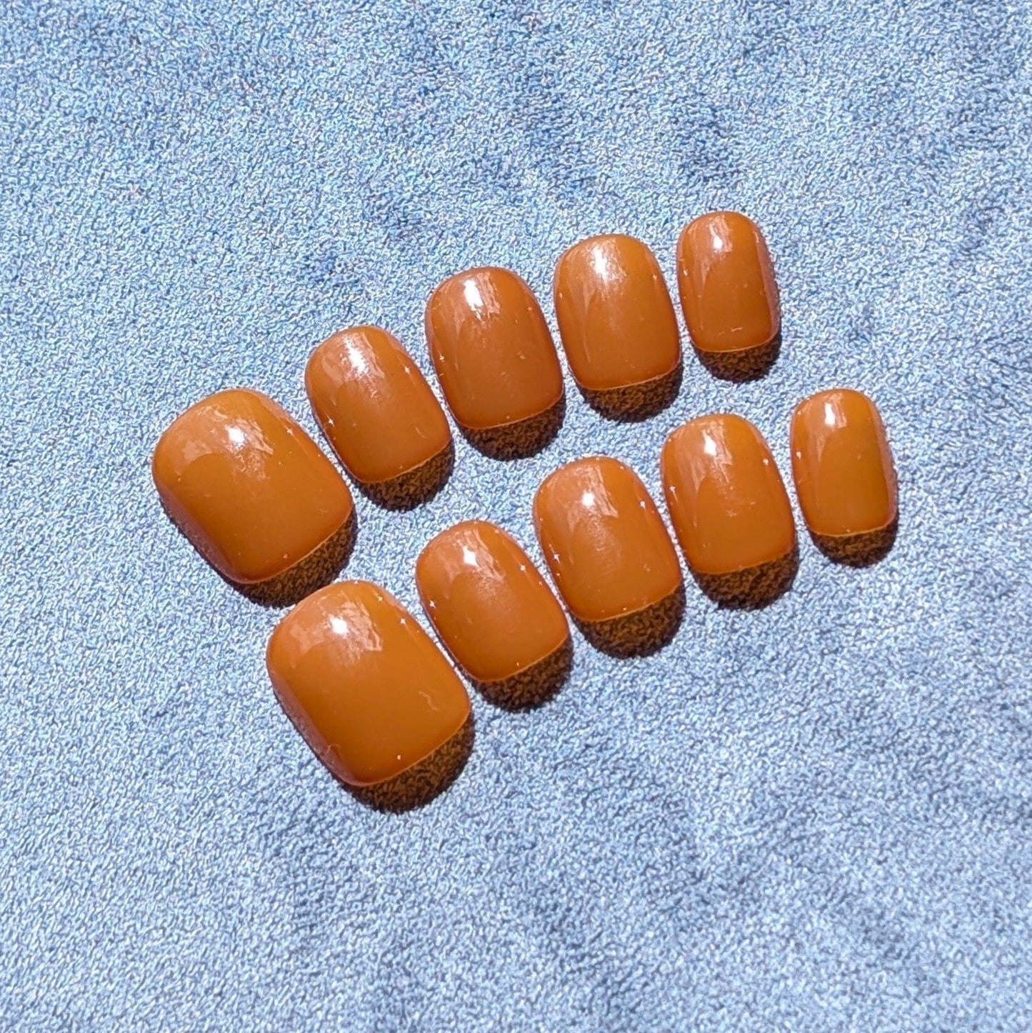 Premium handmade press-on nails in neutral caramel  in extra short round.