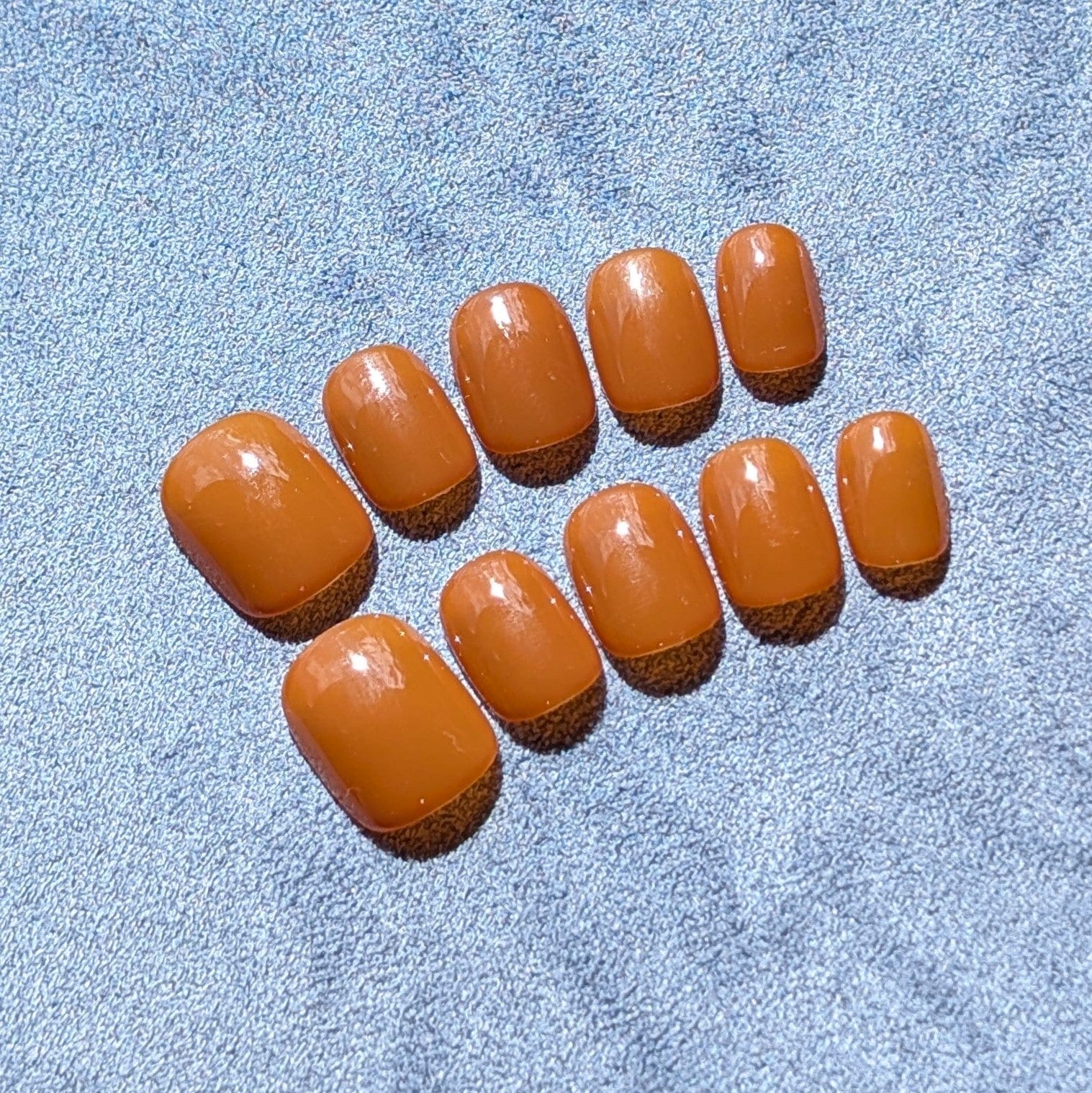 Premium handmade press-on nails in neutral caramel  in extra short round.