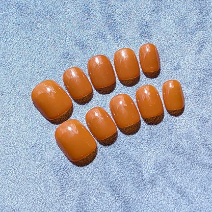 Premium handmade press-on nails in neutral caramel  in extra short round.