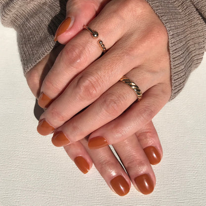 Hands modelling salon quality press-on nails in high gloss rich caramel.