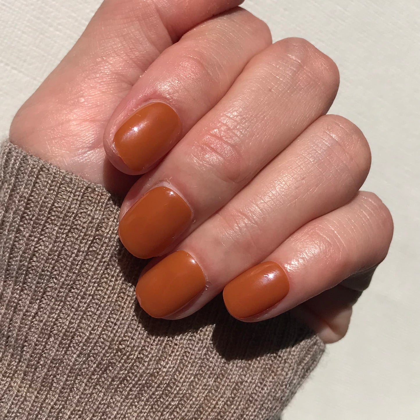 Close up of salon quality toffee press-on nails in extra short. 