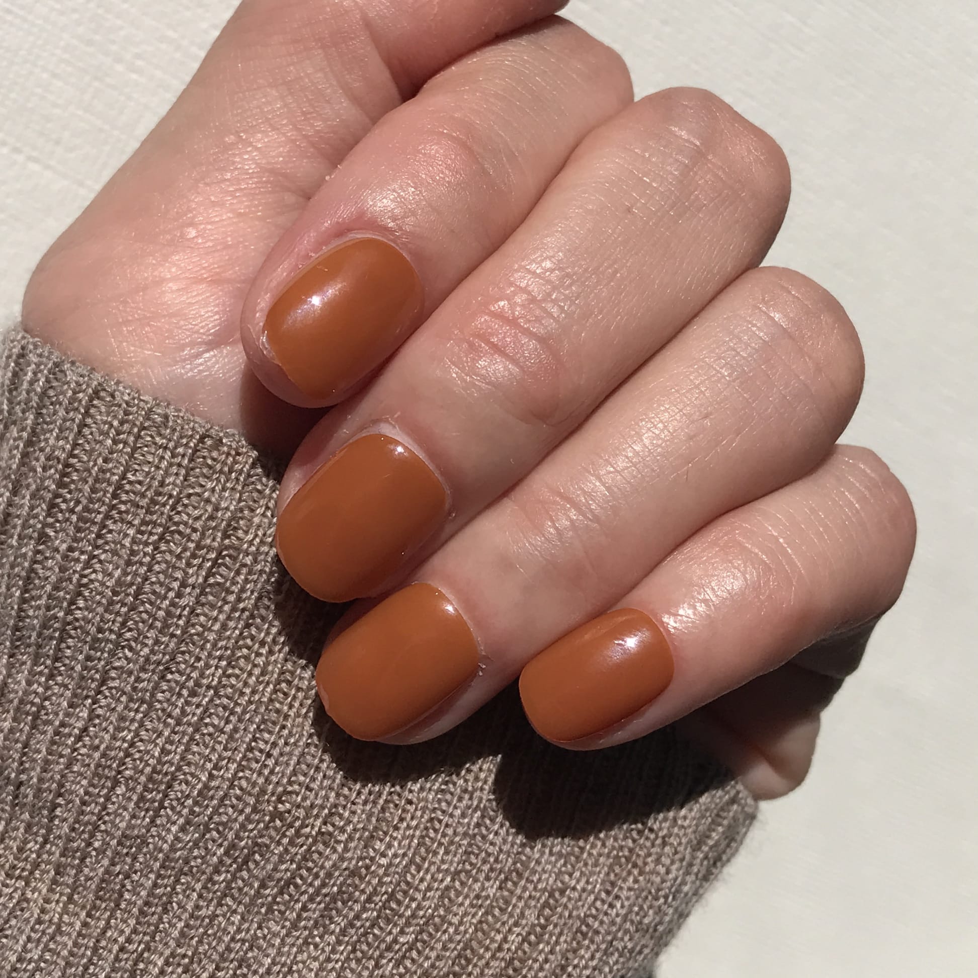 Close up of salon quality toffee press-on nails in extra short. 
