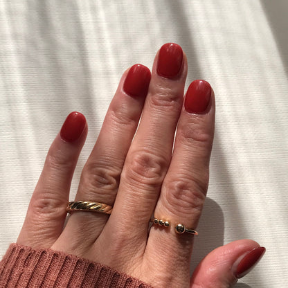 Warm red press-on nails using premium high gloss gel in extra short. 