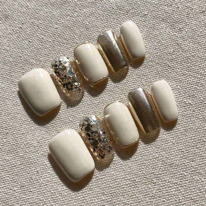 Calm Storm premium handmade press-on nails in white and gold with gold glitter detail.
